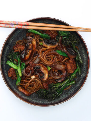 Yaki udon stir-fried noodles served on a plate with chopsticks resting on the edge of the plate.