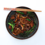 Yaki udon stir-fried noodles served on a plate with chopsticks resting on the edge of the plate.