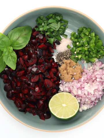 Overhead cherry salsa ingredients in a bowl, chopped but not combined.