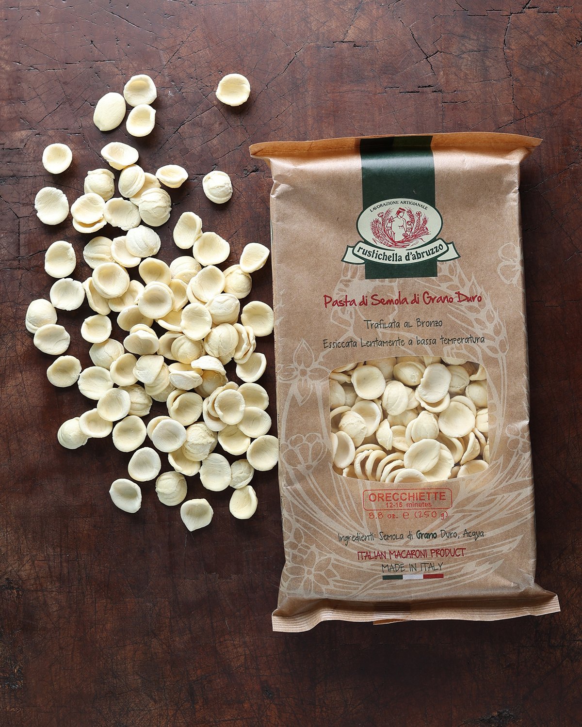 A bag of orecchiette pasta with some spilling out on the side.