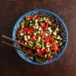 Beautifully painted serving bowl with a Jerusalem salad with tomatoes and cucumbers served in it.