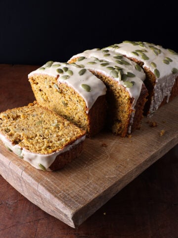 Thick slices of harvest pumpkin banana bread with a maple glaze on top served on a trivet.