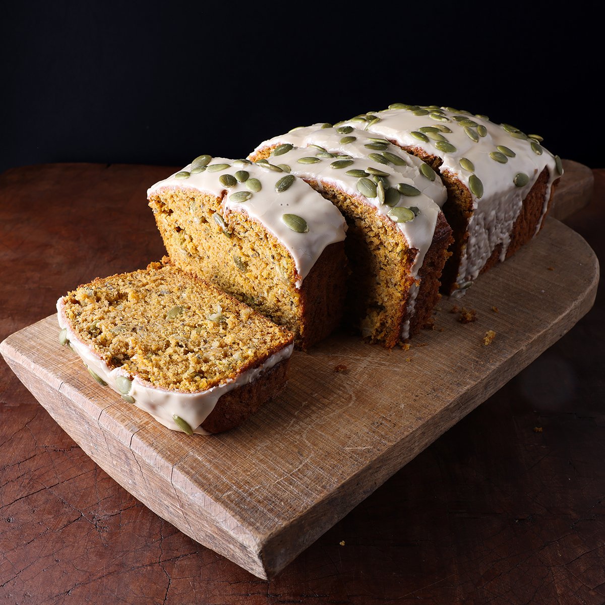 Thick slices of harvest pumpkin banana bread with a maple glaze on top served on a trivet.