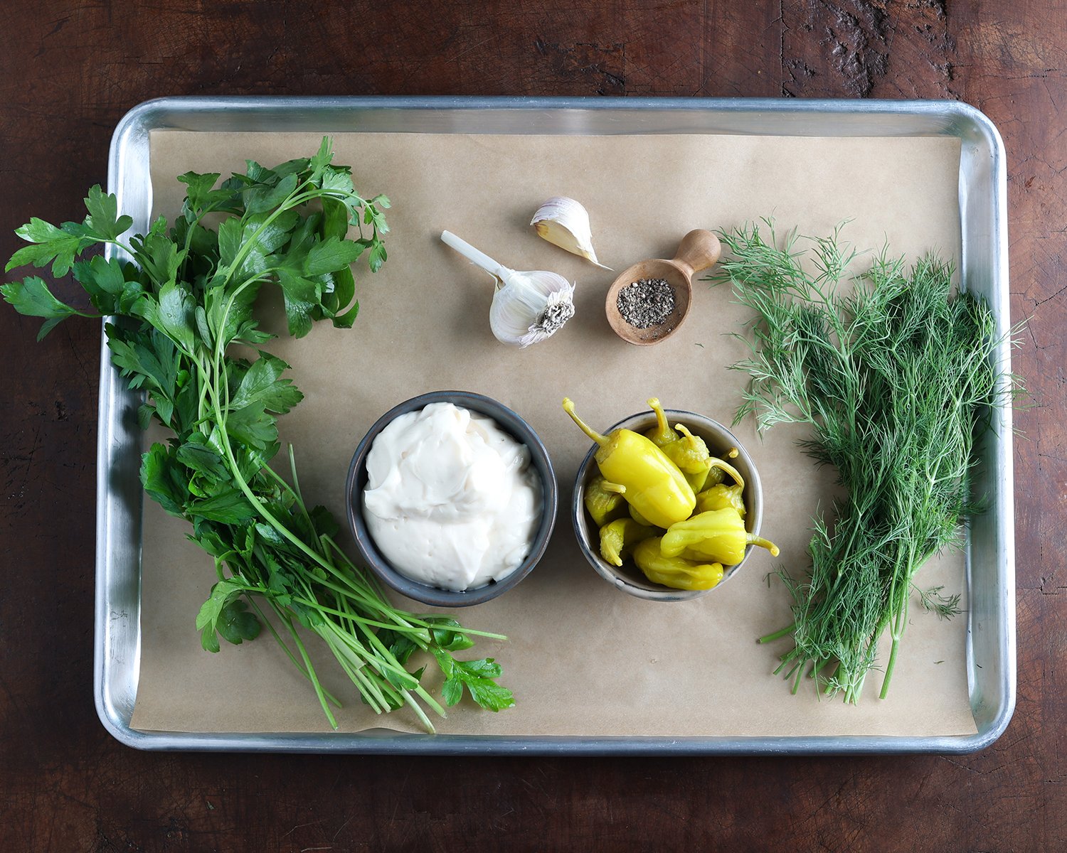 Ingredients used to prepare pepperoncini mayo laid out on a baking sheet.