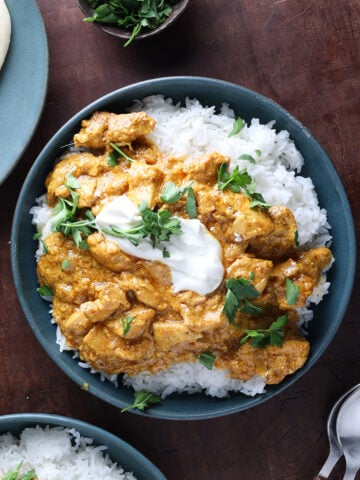 Chicken korma curry served over rice in a bowl.