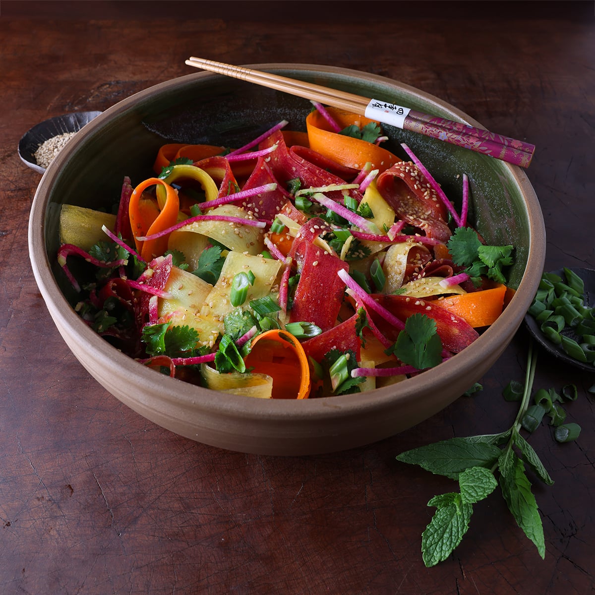 Fresh mint laying next to miso carrot ribboned carrot salad.