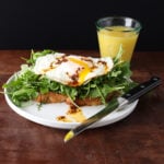 Toasted topped with greens, garlic confit, fried egg and topped with chile de arbol oil.