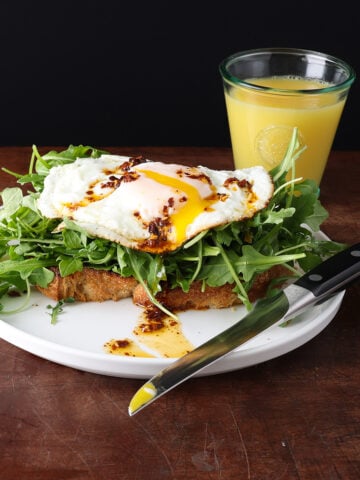 Toasted topped with greens, garlic confit, fried egg and topped with chile de arbol oil.