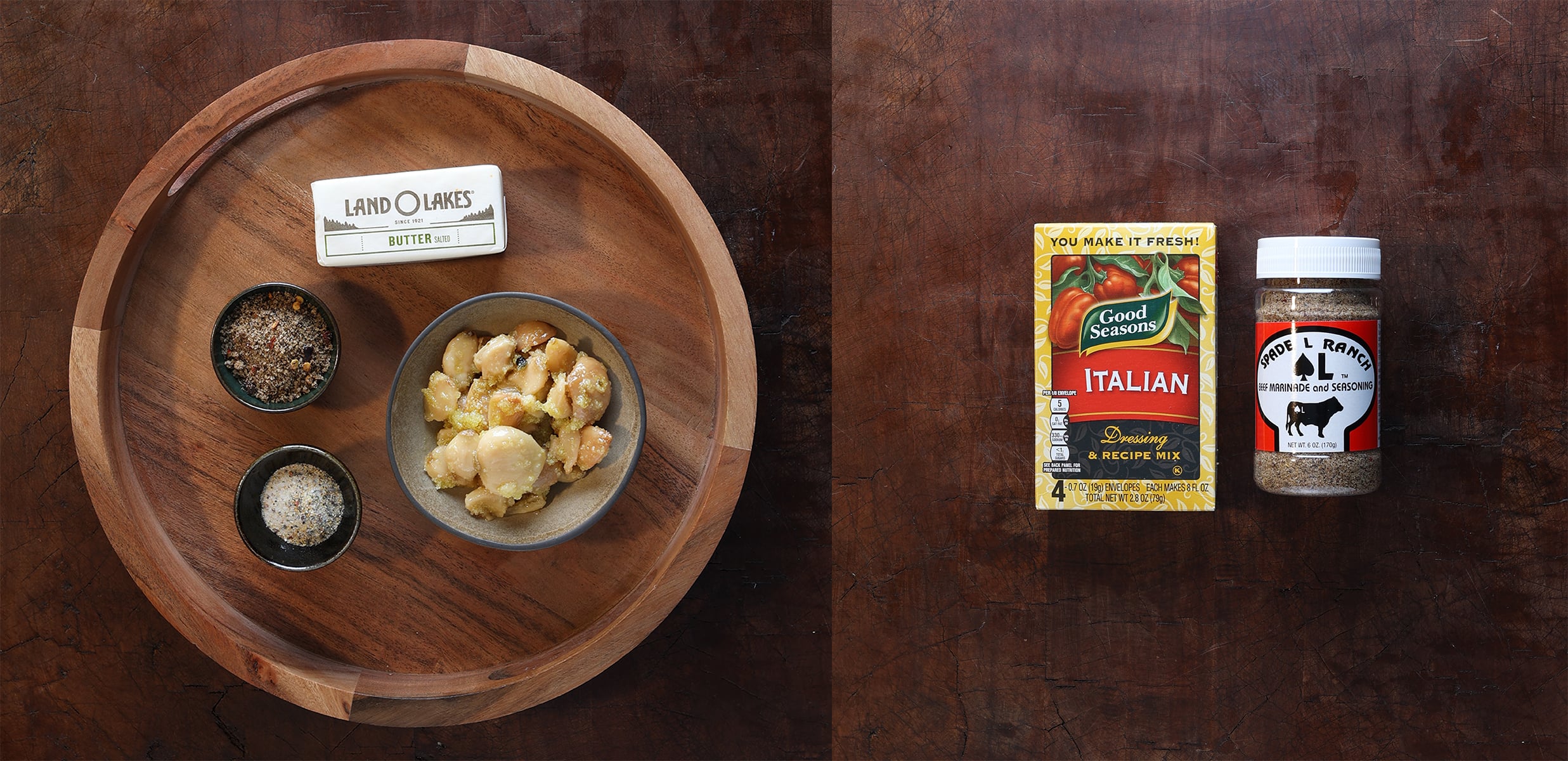 Garlic confit butter ingredients laid out on a tray and a small envelope in a paper packet next to a container of beef marinade.