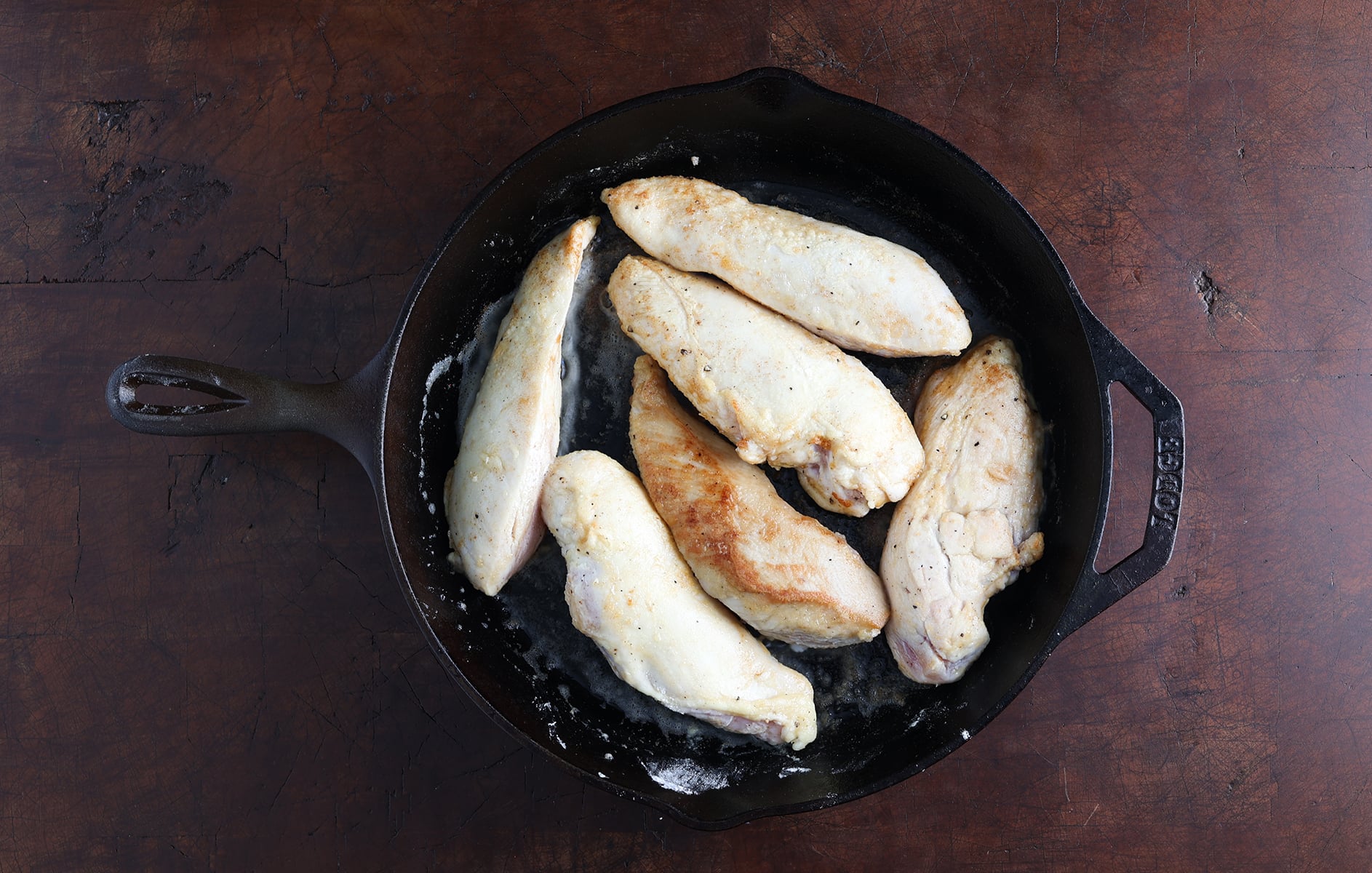 Golden brown chicken breasts in a skillet.