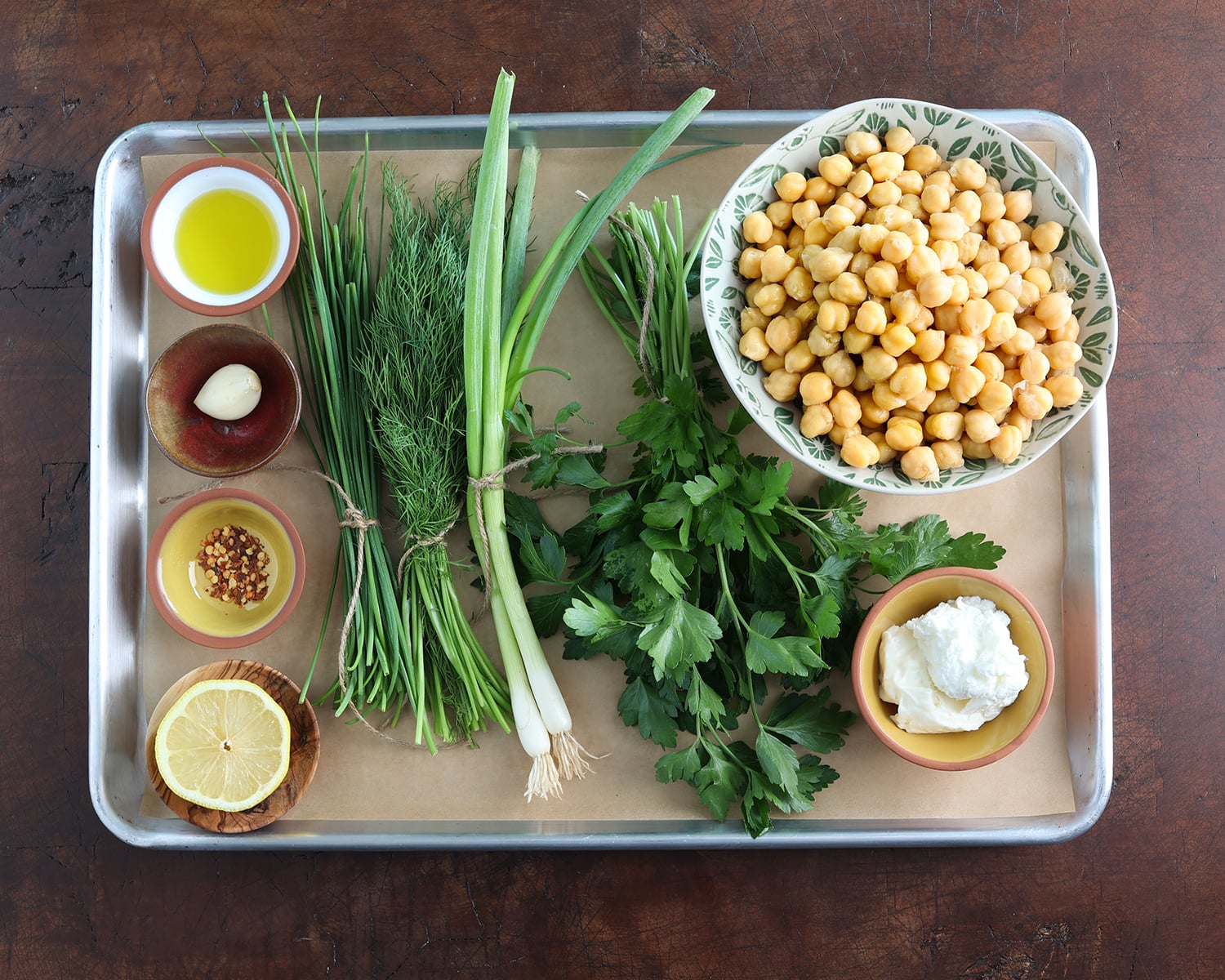 Baking sheet holding all the whole ingredients used to prepare smashed chickpea salad sandwiches.