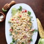 Close up of a grilled corn pasta salad served over arugula.