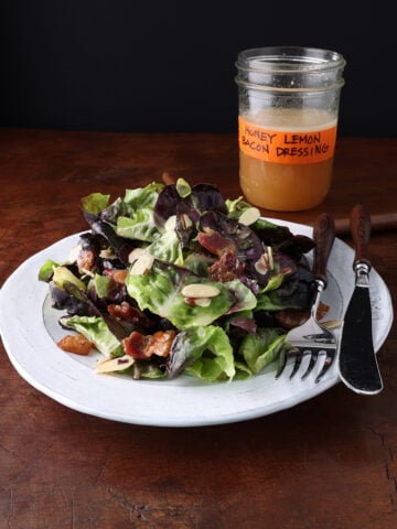 Freshly served dodo dinner salad on a plate with bacon and almonds.