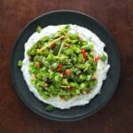 Top view of sprint sugar snap pea salad served over an herby Greek Yogurt on a plate.