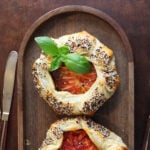 Fresh sprig of basil on a tomato galette.