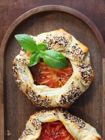 Fresh sprig of basil on a tomato galette.