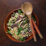 Top view of a Vietnamese chicken vermicelli salad with fresh herbs in a large wooden bowl.