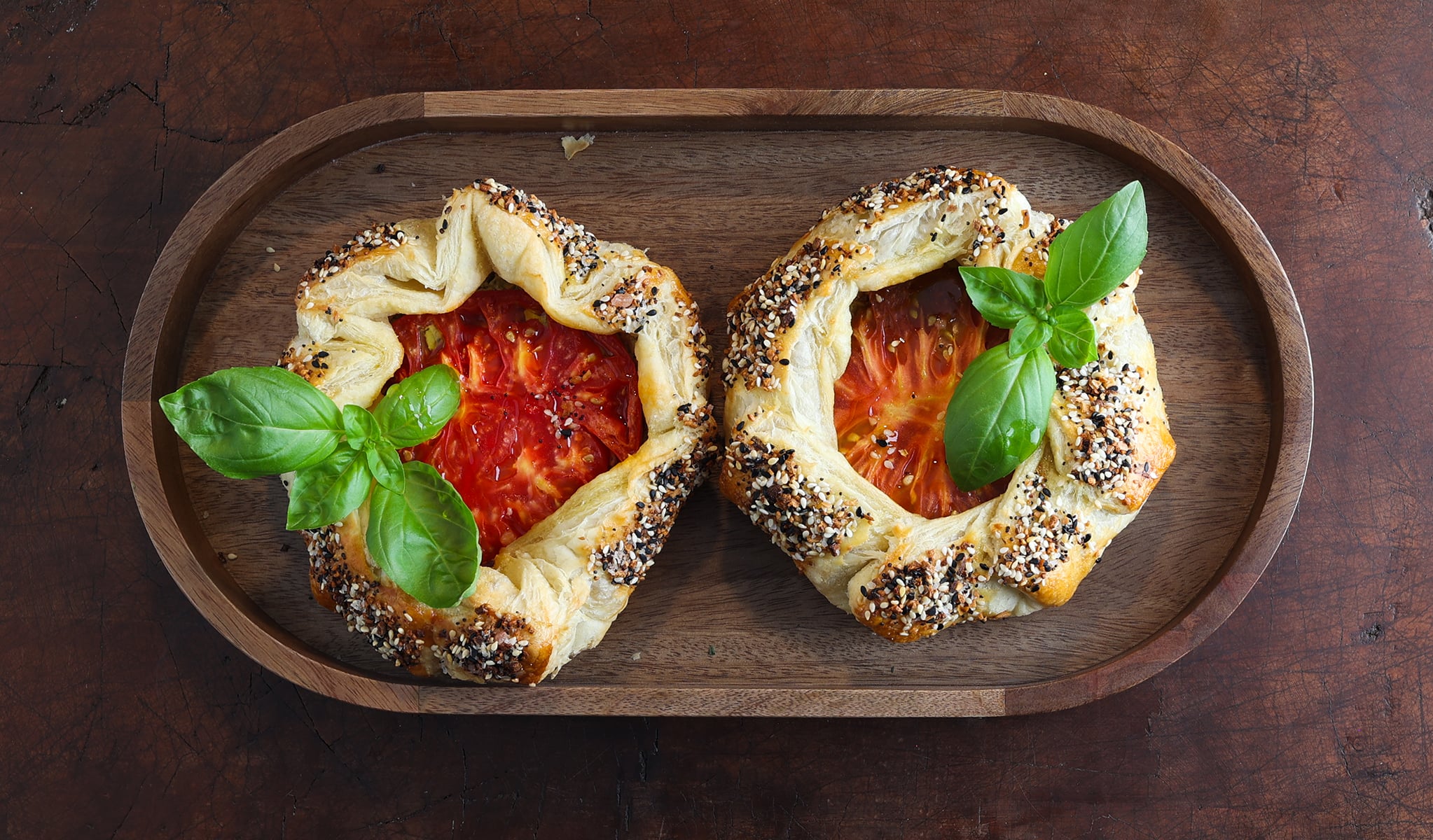 Herby tomato galettes served on a wooden trivet.